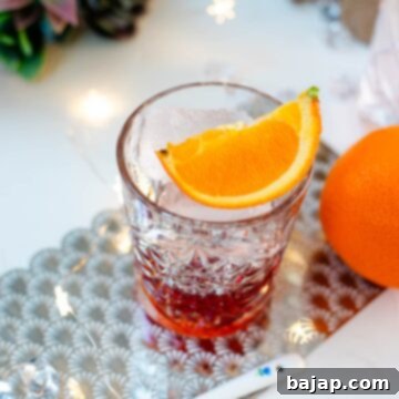 Gorgeous Negroni cocktail, served with a juice orange wedge.
