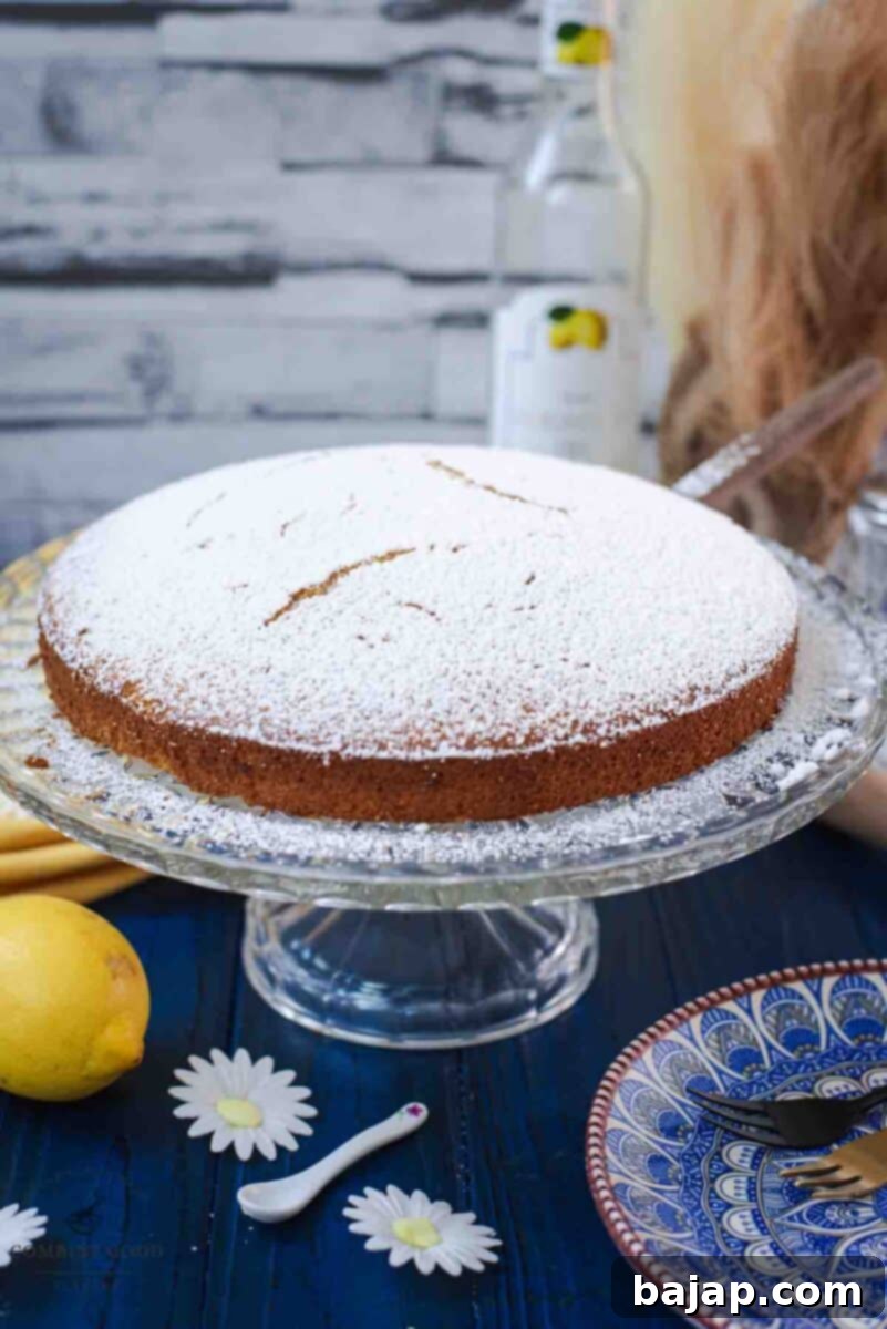 Delicious limoncello ricotta cake on a glass cake stand.