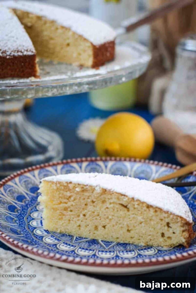 Delicious limoncello ricotta cake slice on a cute blute white colored plate. The light and fluffy limoncello ricotta cake is the perfect summer dessert. Simple ingredients, dreamy texture, and a splash of Italian charm—done in under an hour!