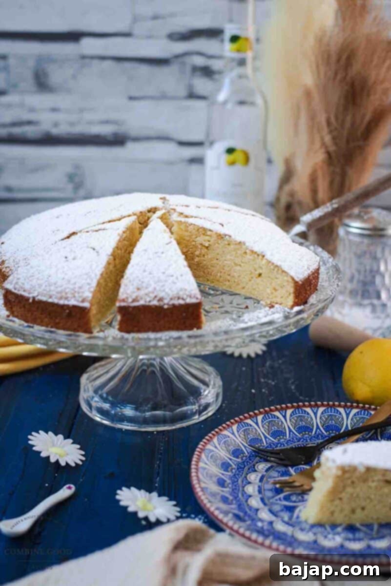 Delicious limoncello ricotta cake, sliced, on a glass cake stand.