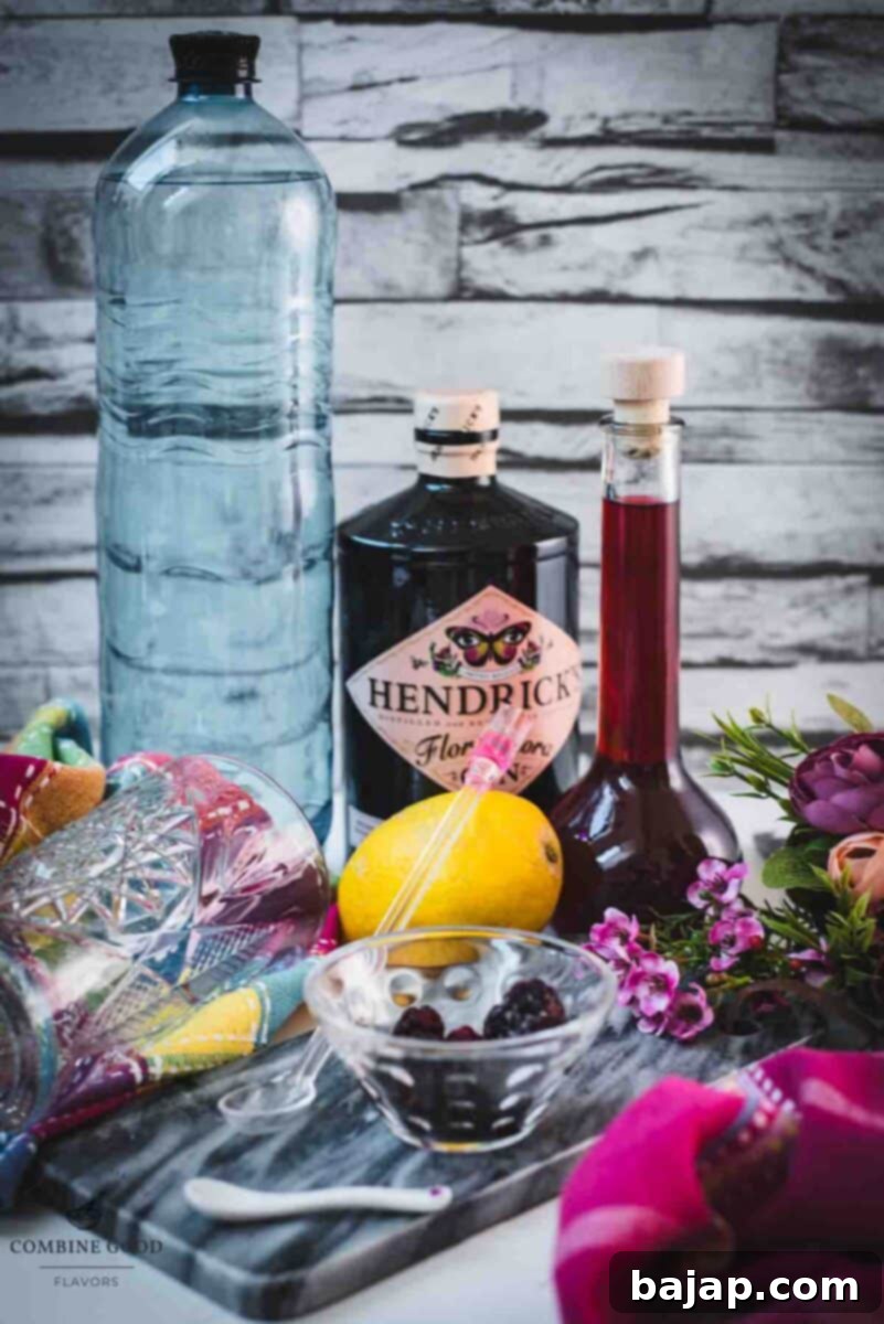 All the ingredients for a refreshing blackberry raspberry gin fizz: soda water, gin, homemade blackberry raspberry liqueur, and a fresh lemon.
