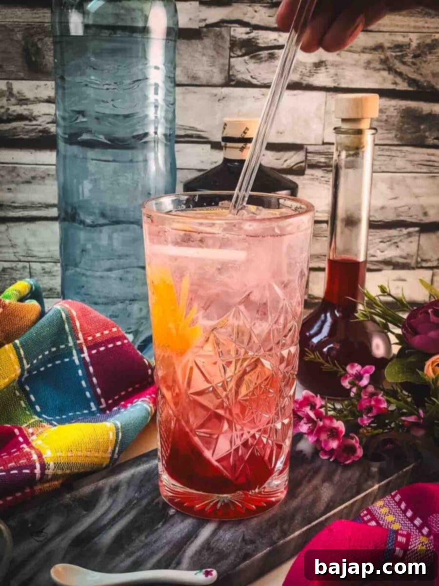 Give your blackberry raspberry gin fizz a gentle stir to mix the ingredients thoroughly.