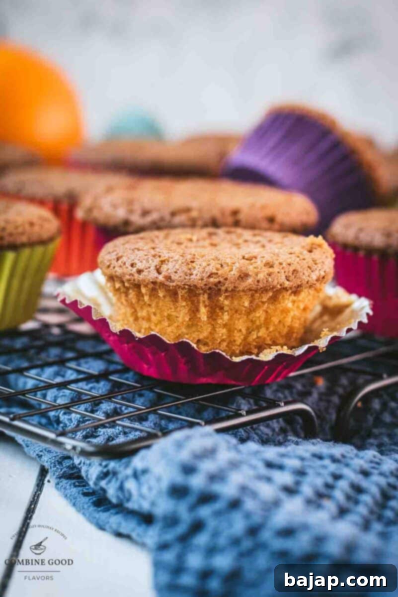 Zesty Orange Muffins 2 Beautifully baked fluffy orange muffins cooling on a wire rack, ready to be enjoyed.