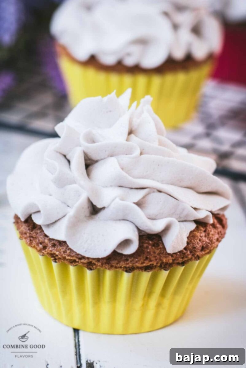 Ready to serve orange muffins with lavender buttercream. Placed on white wooden ground.