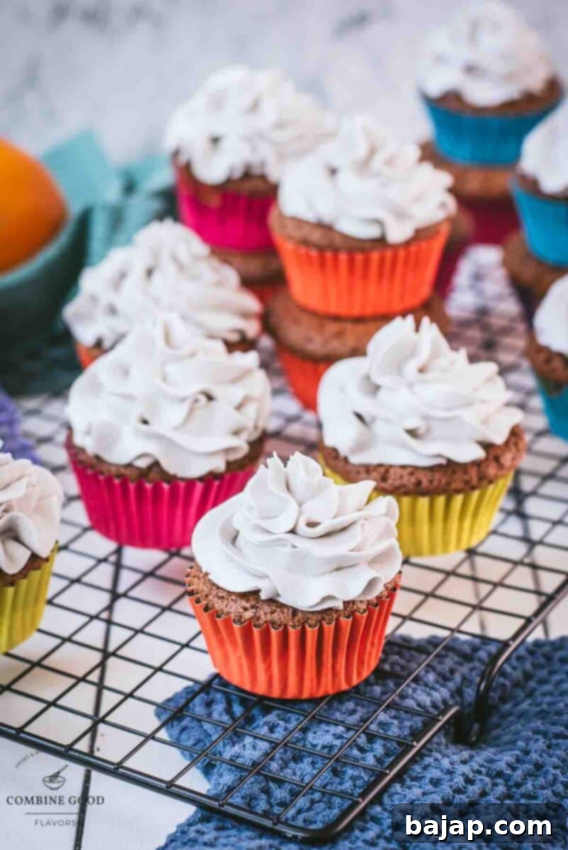 Ready to serve orange muffins with lavender buttercream. Placed on cooling rack.