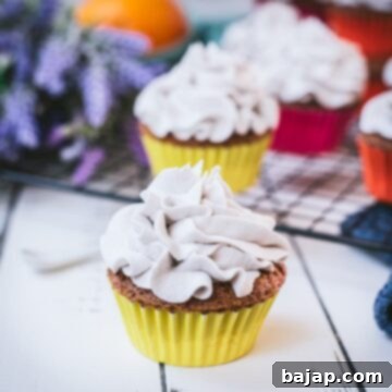 Ready to serve orange muffins with lavender buttercream. Placed on white wooden ground.