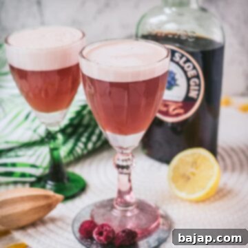 Divine ruby fizz cocktail, placed on mirrored coaster and served in a red and a green glass.