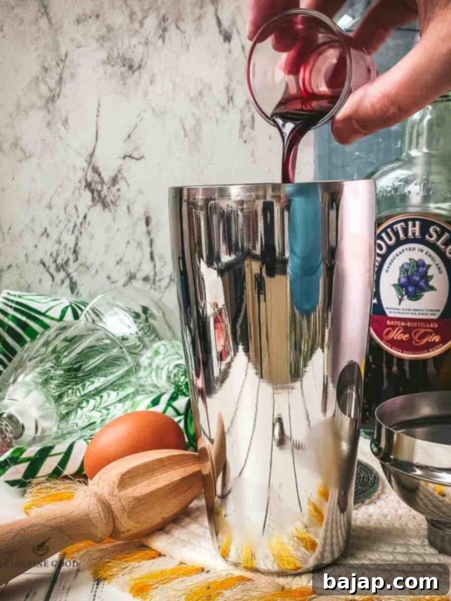 Add raspberry syrup to the cocktail shaker.