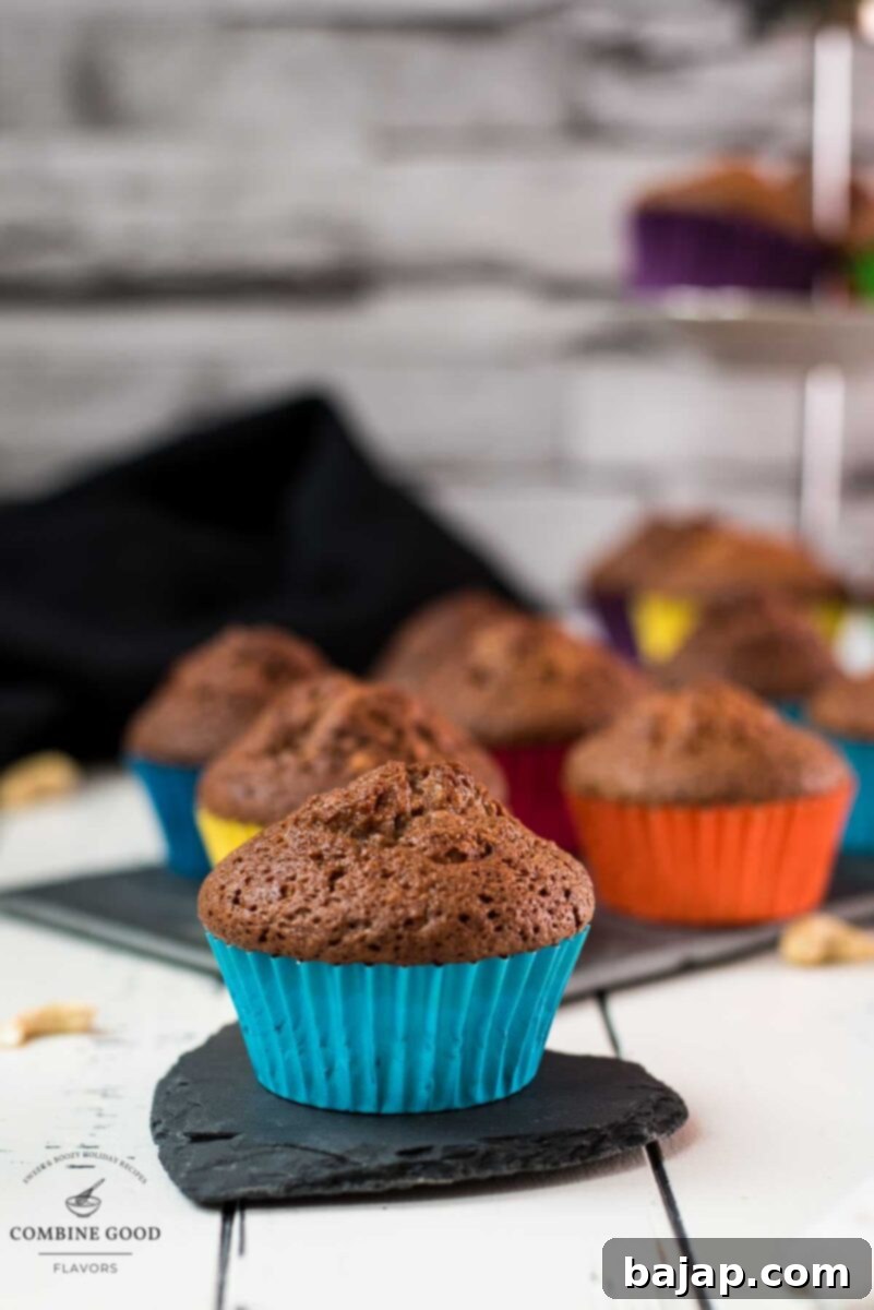 Delicious rum cashew muffins, still warm and beautifully golden, arranged invitingly on a dark slate plate, ready to be enjoyed.