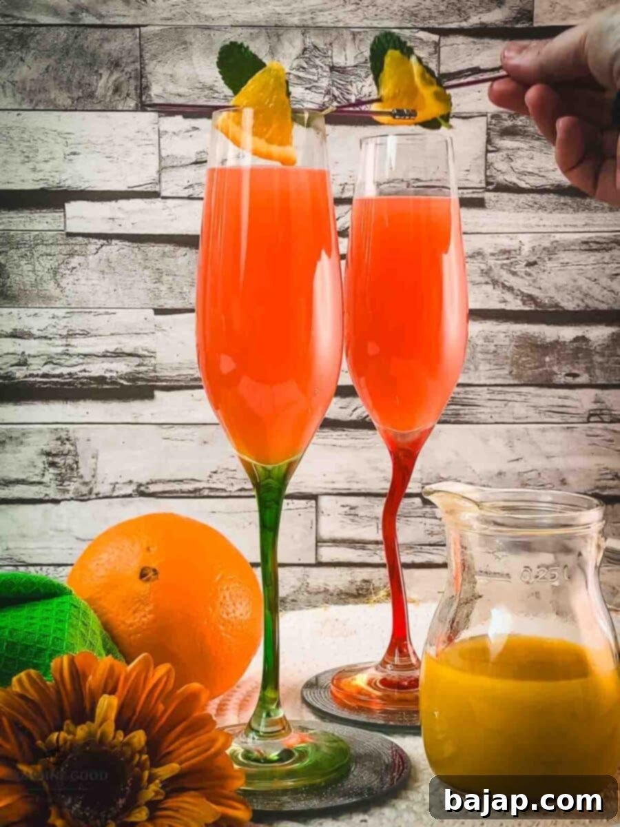 Garnishing the Campari Mimosa with an orange slice and mint leaf on a cocktail skewer, enhancing its visual appeal.
