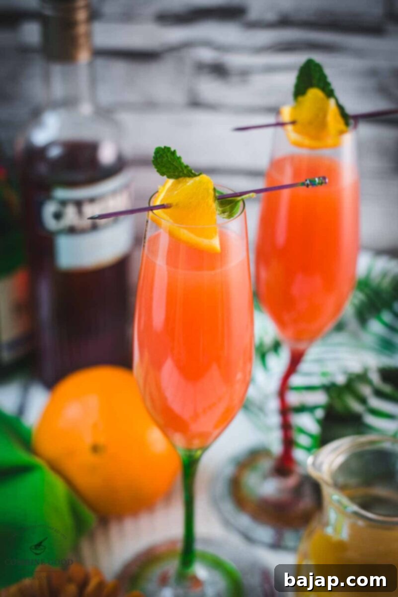 A tray of Campari Mimosas, each beautifully garnished, ready for a party or celebration.
