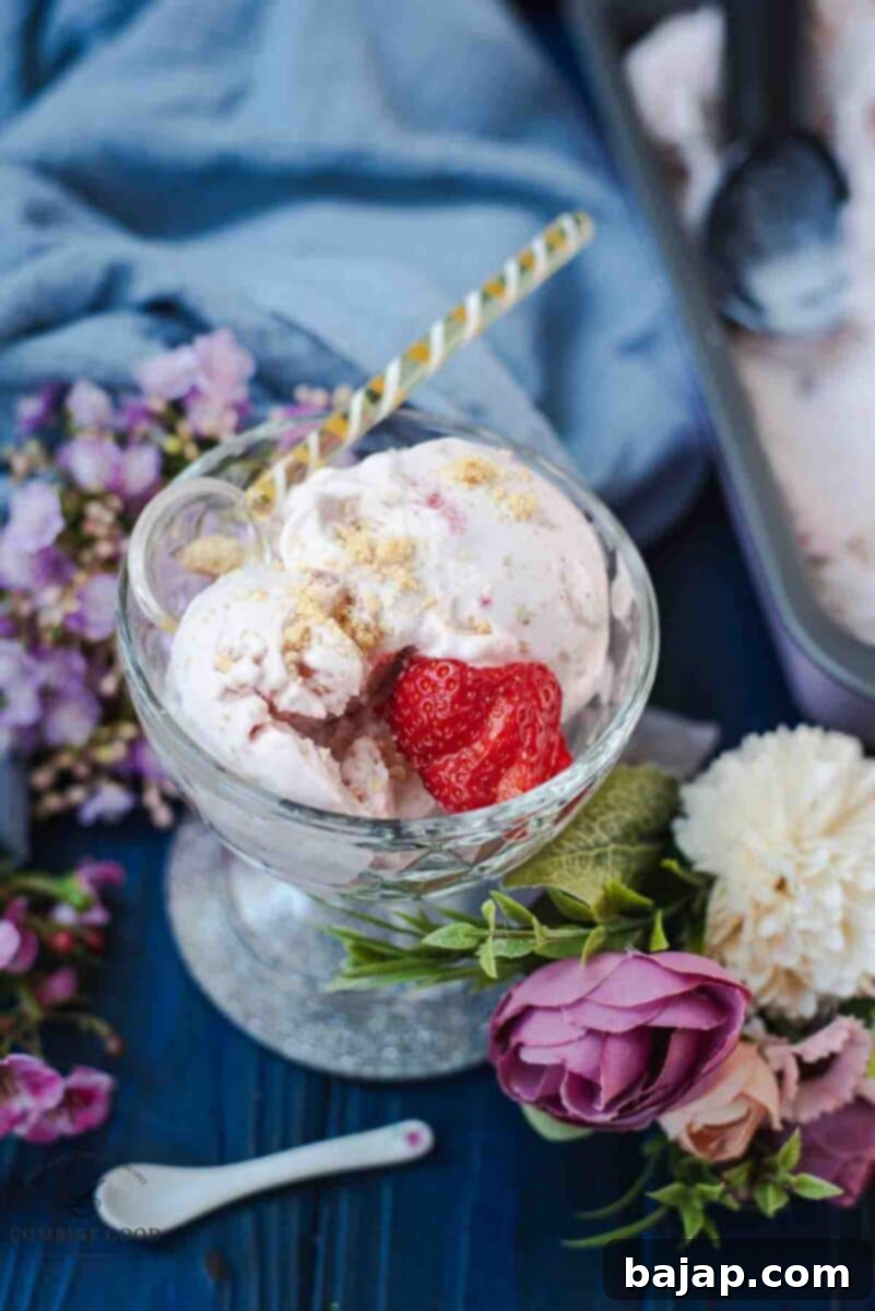 Glass serving bowl, filled with delicious strawberry shortcake ice cream. Garnished with fresh strawberries and shortbread cookie crumbs.