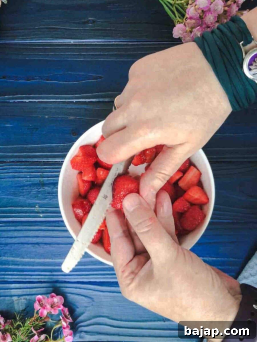 Cutting the fresh strawberries into small cubes.