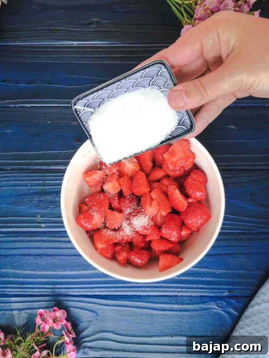 Adding the granulated sugar to the chopped strawberries.