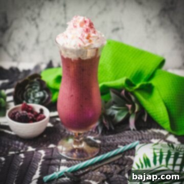 Boozy berry adult milkshake with homemade Chambord, served in Hurricane glass. Garnished with whipped cream and dusted with edible glitter. Served with a drinking straw.