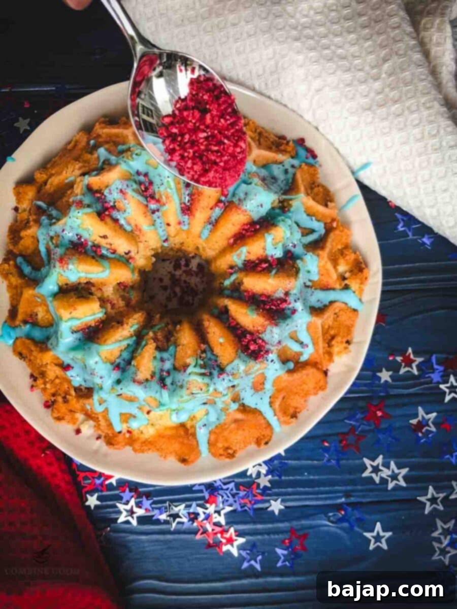 Sprinkling freezer dried raspberry dust on top of the blue drip glaze.