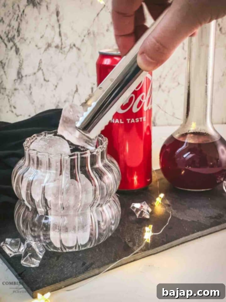 Add cubed ice to the serving glass.