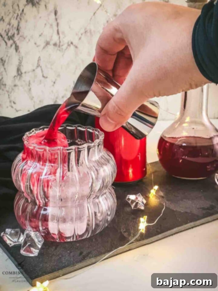 Pour the homemade Chambord into the cubed ice filled serving glass.