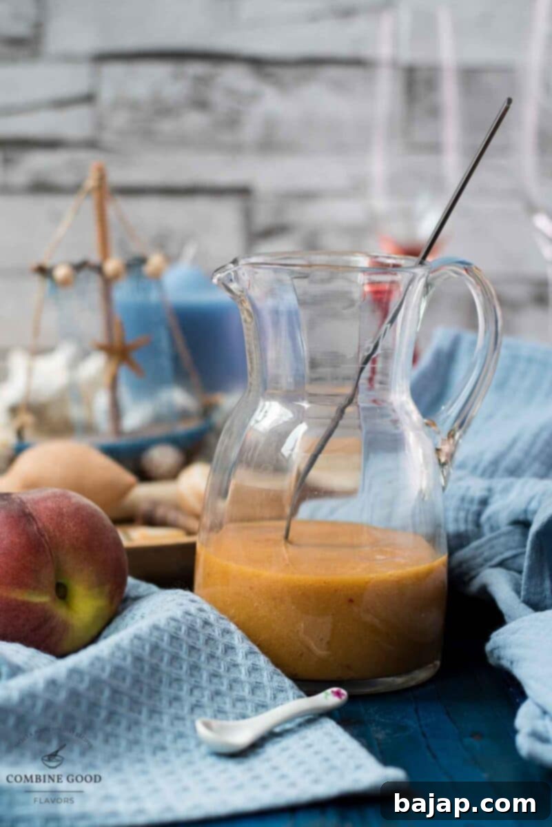 Golden Peach Purée: Perfect for Bellinis and Beyond 8 Freshly made peach puree in a glass jug, ready for use or storage.