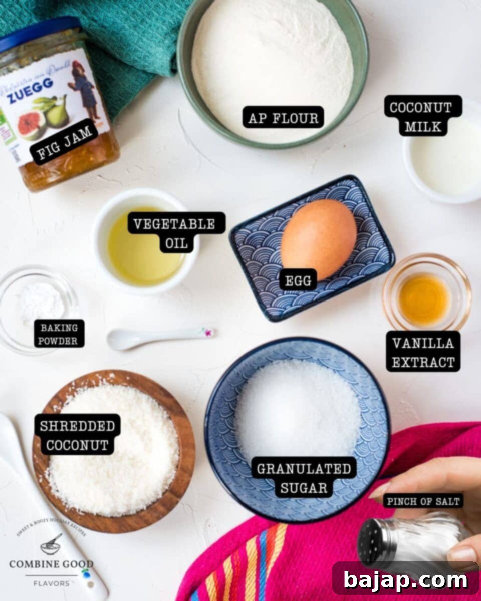 Assortment of fresh ingredients for coconut muffins, including shredded coconut, fig jam, eggs, oil, milk, sugar, flour, baking powder, vanilla extract, and salt.