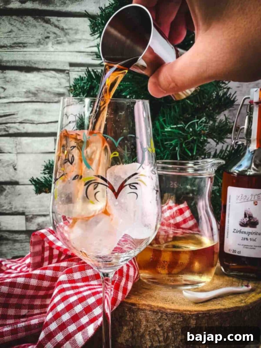 Pouring Zirben schnapps into a glass with ice, the first step in making the Zirben Spritzer.