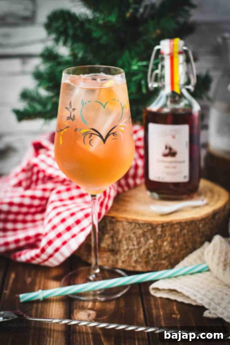 Delicious Zirben Spritzer served in white wine glass. Placed on wooden ground, next to a flask of Zirben Schnapps.