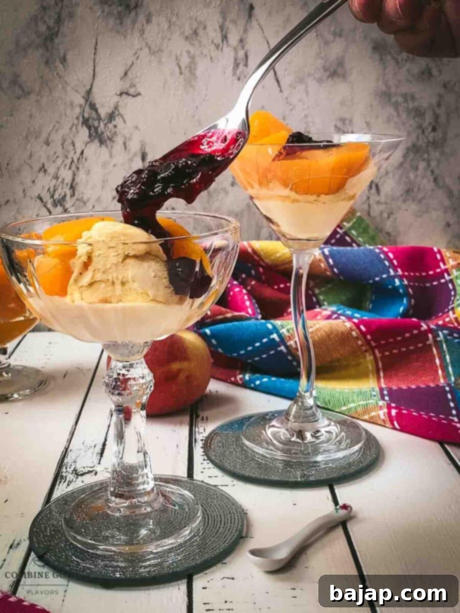 Spoon the homemade berry sauce over the vanilla ice cream and peach-filled cocktail glass.