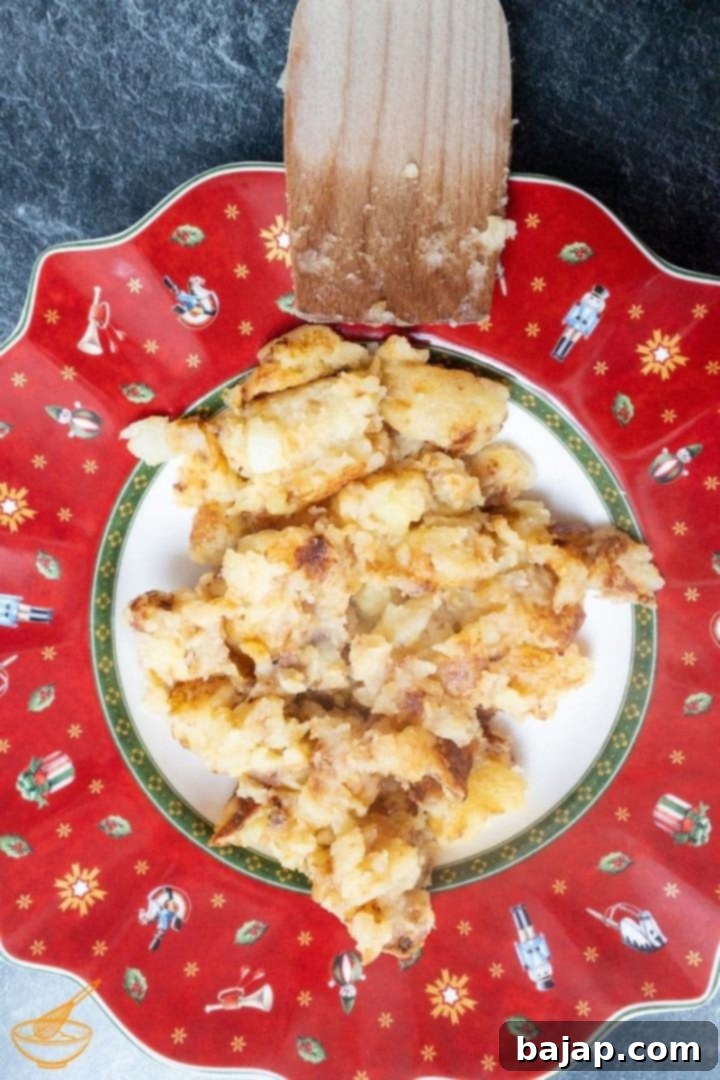Grated potatoes frying in a pan with onions, Austrian style Erdäpfelschmarrn preparation