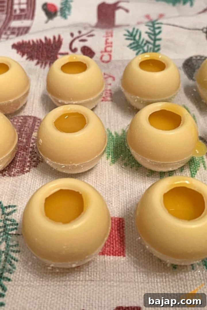 Fill the hollow spheres with the white chocolate eggnog ganache until just below the rim.