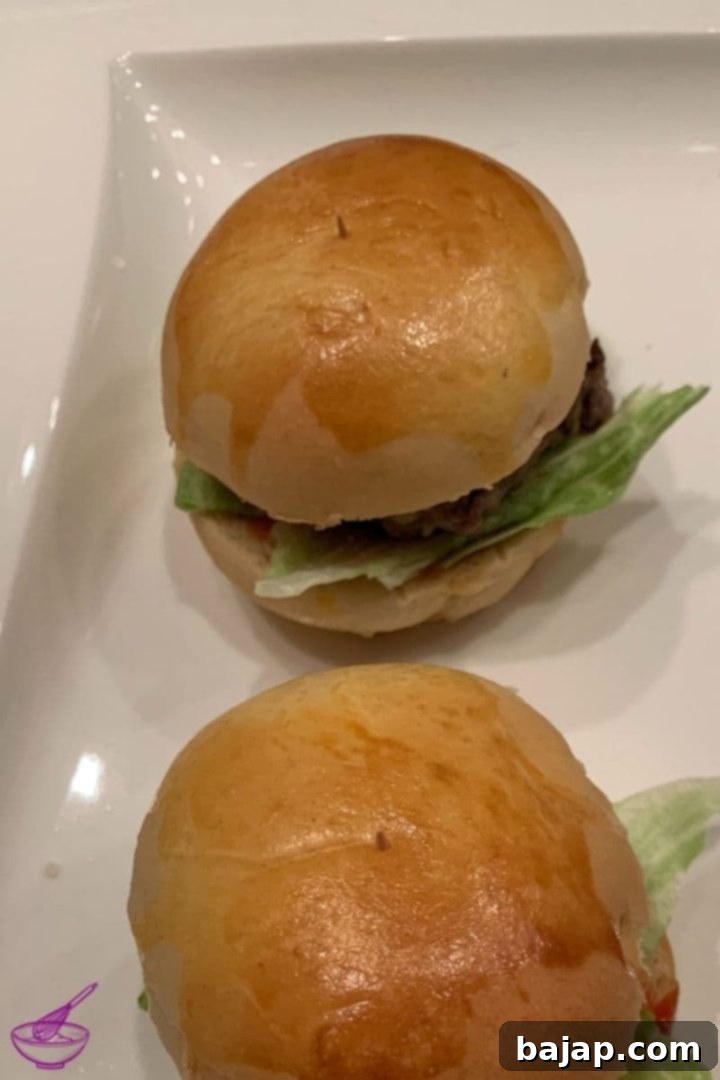 Homemade patties and buns assembled into perfect mini cheeseburgers, garnished with lettuce and a toothpick.