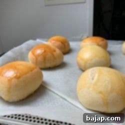 Freshly baked golden-brown mini burger buns.