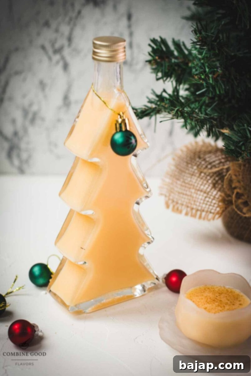 Delicious eggnog in a small icy bowl next to a Christmas tree shaped bottle, filled with eggnog.