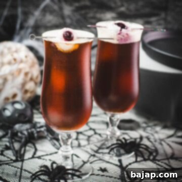 Spooky black velvet cocktail, garnished with eerie lychee eyeballs. A dark, bubbling drink perfect for a Halloween party.