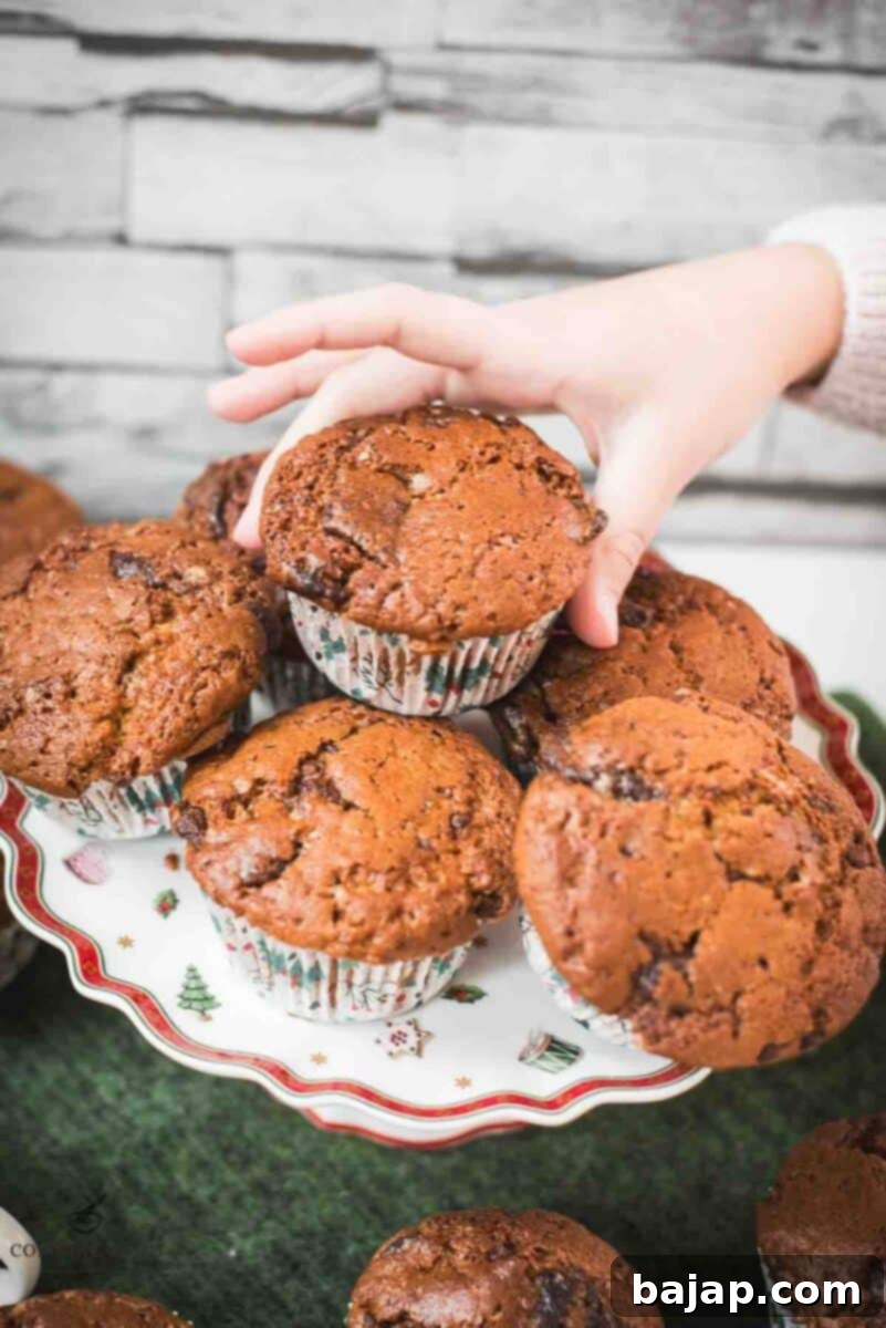 My daughters hand snagging delicious St. Nicholas chocolate muffins from christmassy plate.