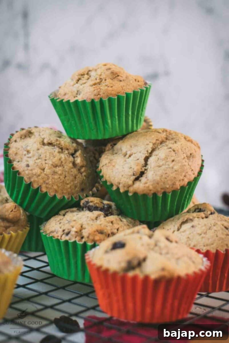 cute fruit and nut muffins with colored lines, stacked on cooling rack.