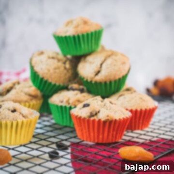 cute fruit and nut muffins with colored lines, stacked on cooling rack.