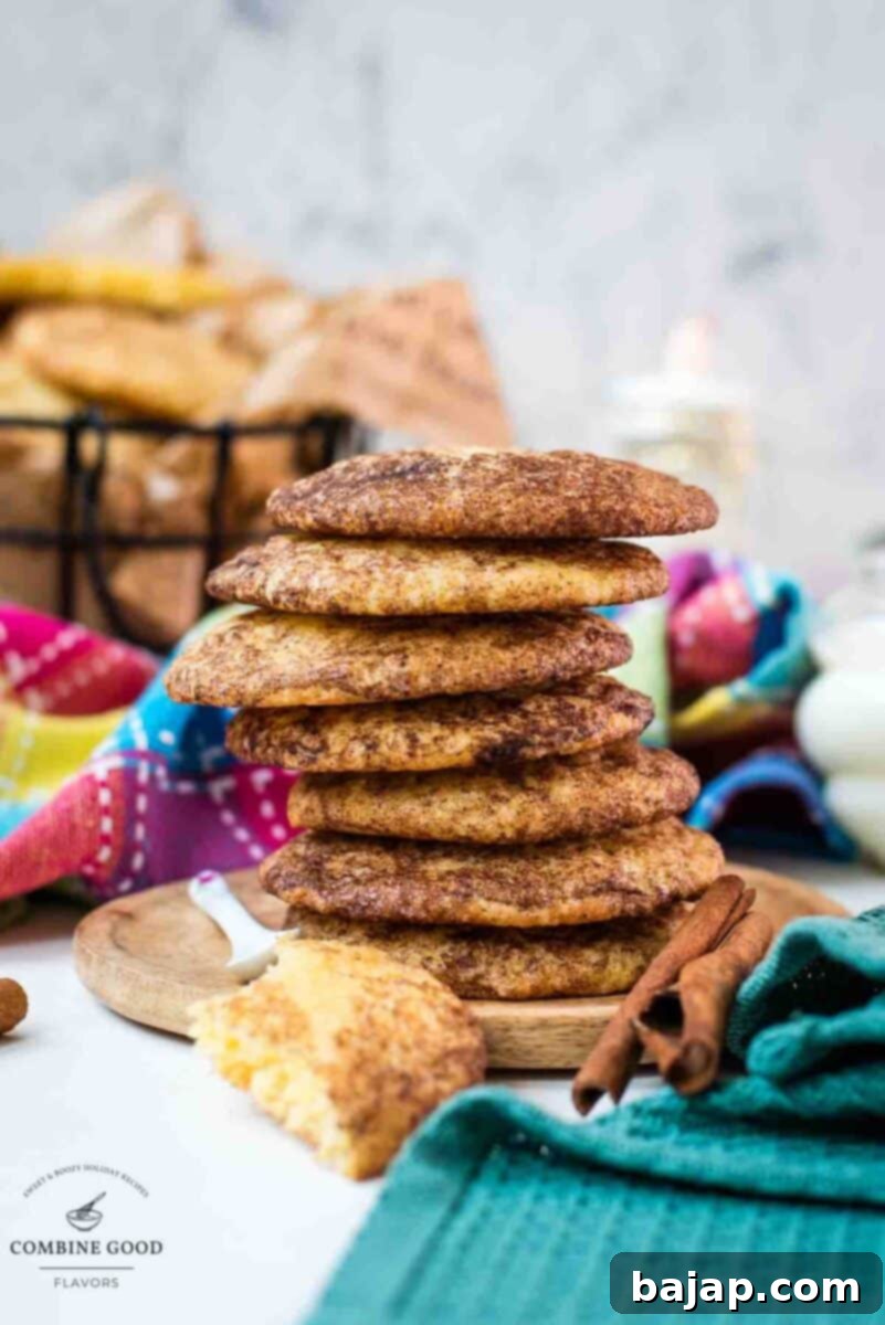 Fluffy snickerdoodle cookies stacked on wooden plate.