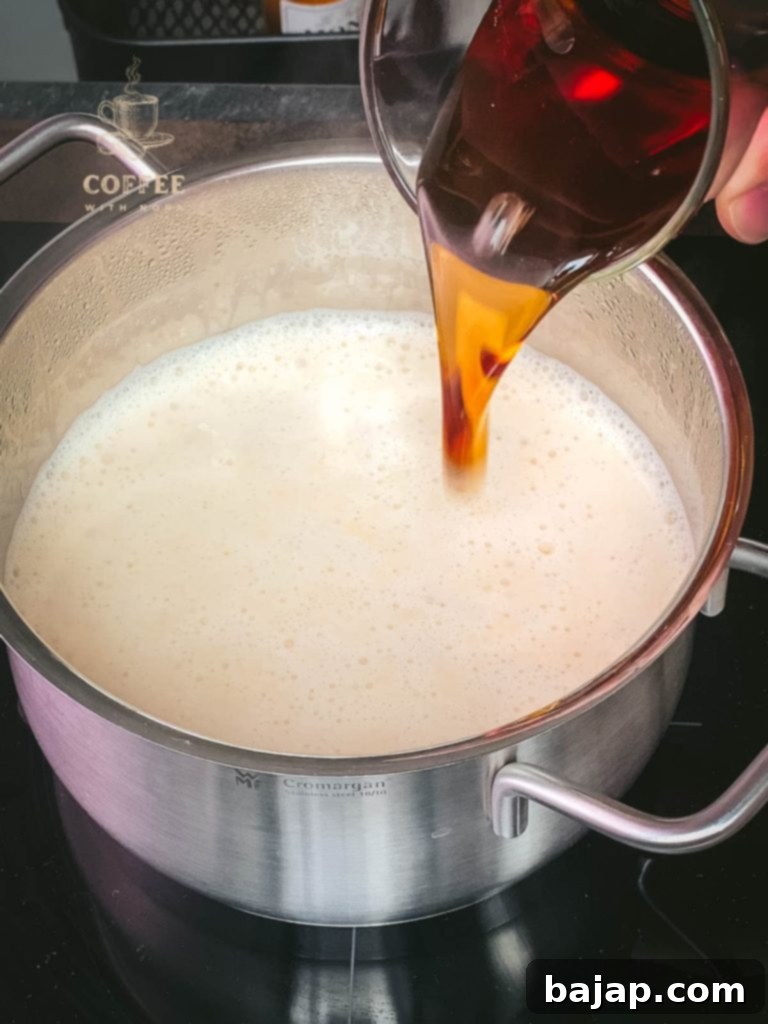 Festive Holiday Coffee Creamer 4 Adding maple syrup and heavy cream to the Christmas coffee creamer mixture.