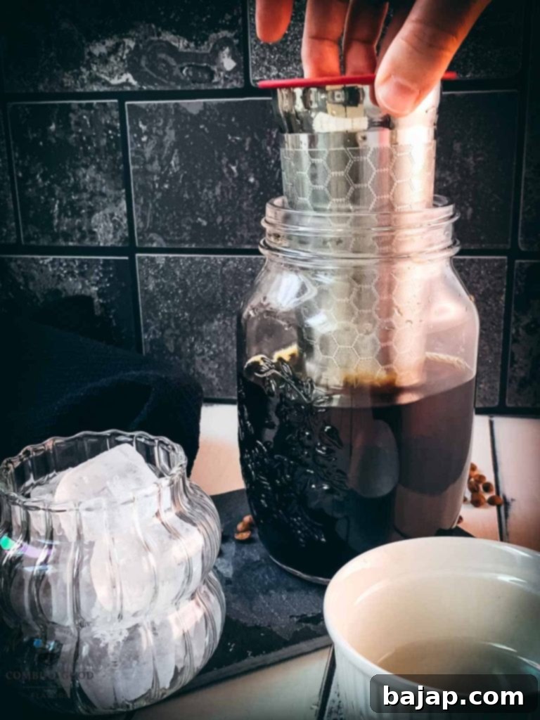 Mason Jar Cold Brew Delight 6 A sieve being removed from a mason jar after steeping.