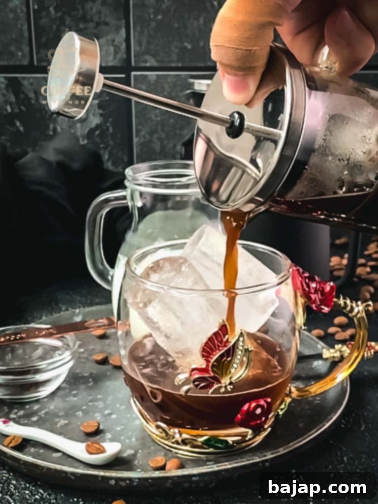 Vanilla Bean Bliss: French Press Iced Coffee 6 Pouring vanilla French press coffee into the glass.
