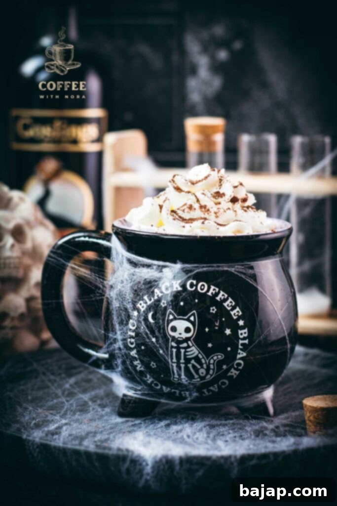 Spooky cauldron coffee mug filled with delicious coffee with rum. Topped with sweetened whipped cream and placed on a black plate surrounded by cobweb.
