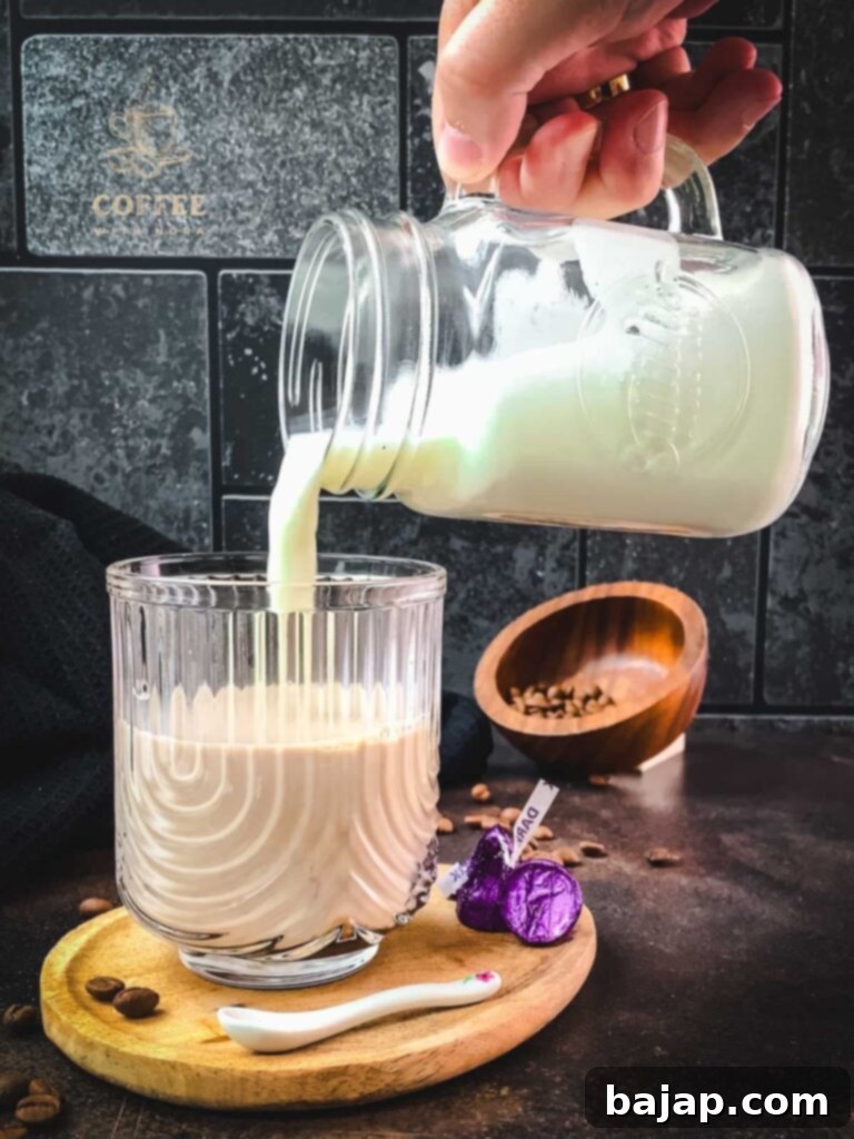 Pouring steamed milk into the espresso and chocolate mixture.