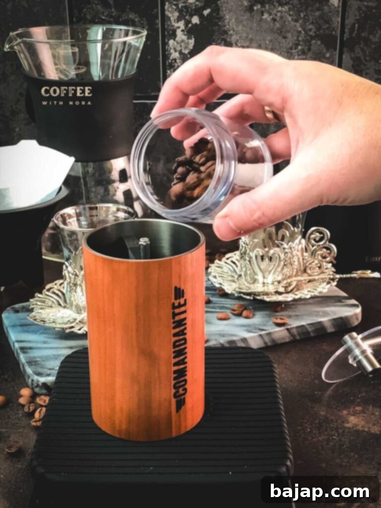 V60 Pour-Over: The Art of the Perfect Cup 3 Filling coffee beans into a manual coffee grinder.