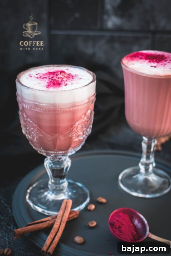 A captivating pink latte served in elegant glasses, displayed on a dark plate.