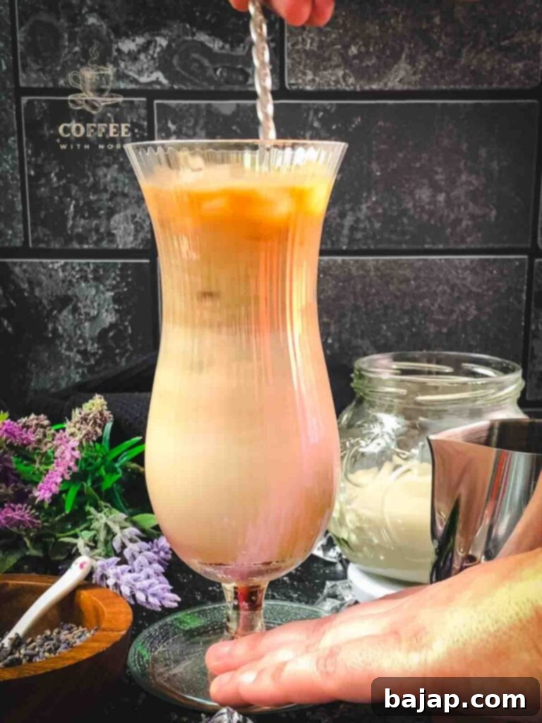 Lavender Dream Iced Latte 6 Stir iced lavender latte with long-stemmed spoon