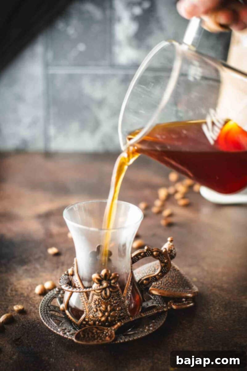 Pouring coffee made with a Kalita wave into a vintage cup.